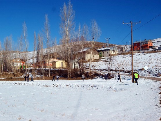İspir yolun da bir köy ve karda top oynayan gençler
